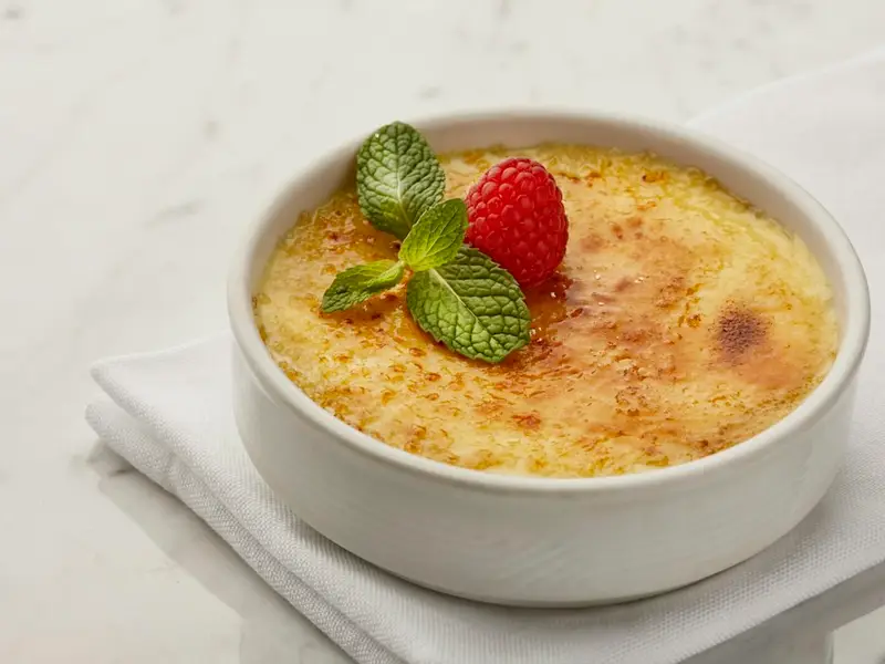 Crema quemada con una frambuesa y hojas de menta