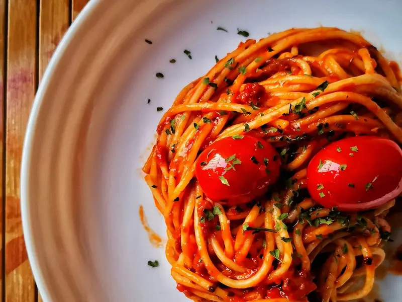 Espaguetis con salsa de tomate y tomates cherry en un plato blanco