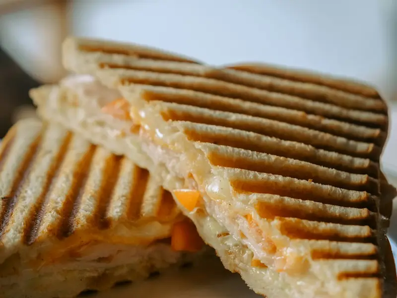 Sándwich tostado a la plancha relleno de queso y carne